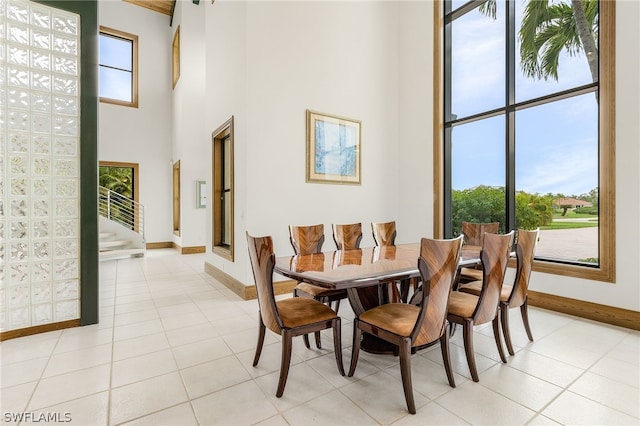 dining room with light tile patterned flooring, a high ceiling, and a wealth of natural light