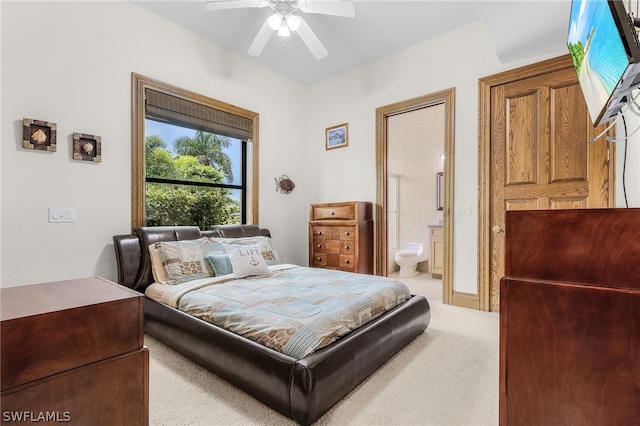 bedroom featuring connected bathroom, ceiling fan, and light colored carpet