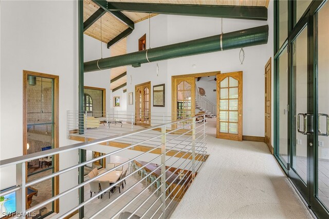 hall featuring carpet flooring, french doors, high vaulted ceiling, and beamed ceiling