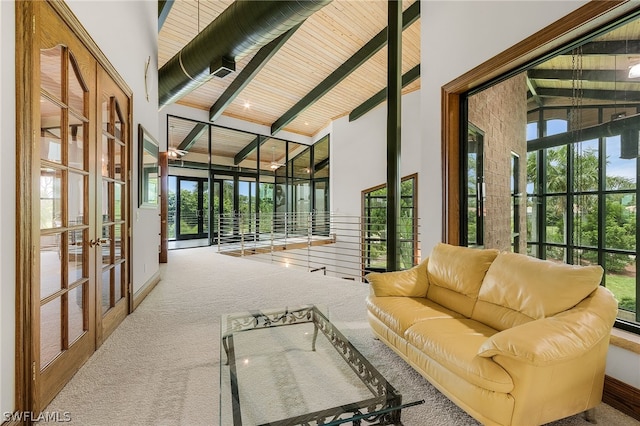 sunroom featuring vaulted ceiling with beams, french doors, and wood ceiling