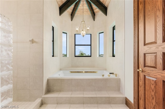 bathroom with wooden ceiling, an inviting chandelier, tile patterned flooring, a relaxing tiled tub, and lofted ceiling with beams