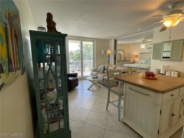 kitchen with a kitchen breakfast bar, light tile patterned floors, a textured ceiling, and a kitchen island