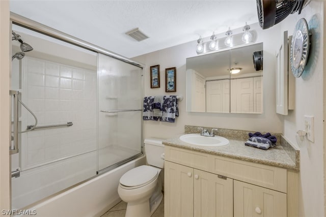 full bathroom featuring tile patterned flooring, combined bath / shower with glass door, toilet, and vanity