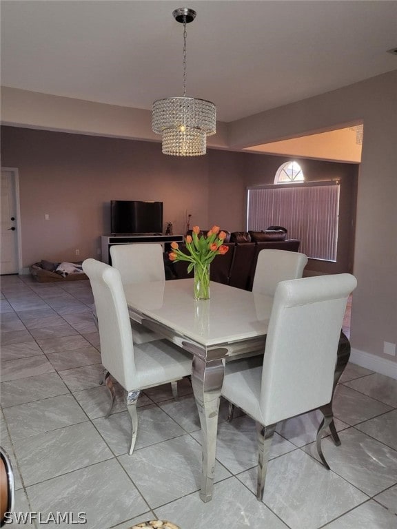 tiled dining area featuring an inviting chandelier