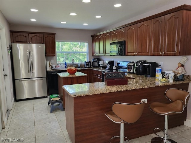 kitchen featuring light tile patterned floors, black appliances, sink, light stone countertops, and kitchen peninsula