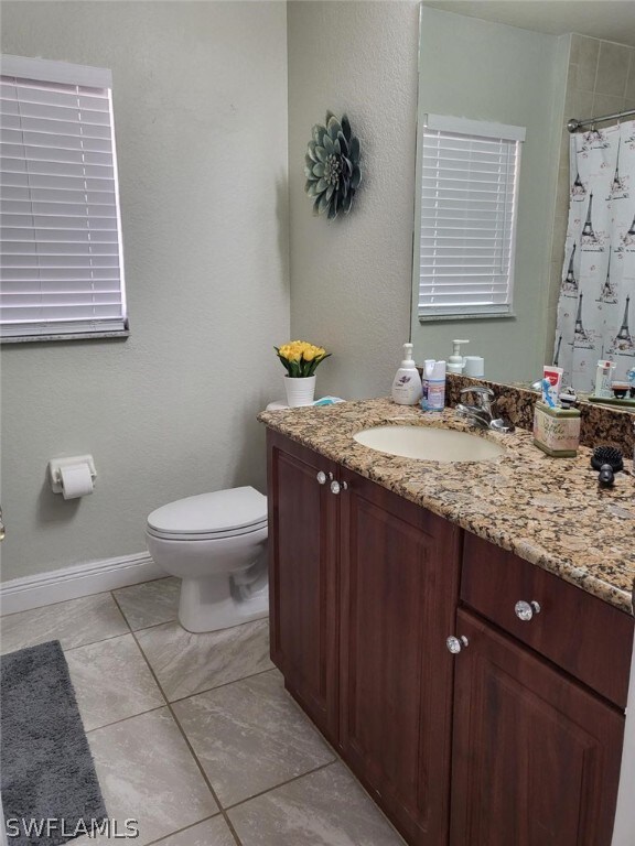 bathroom featuring tile patterned floors, toilet, and vanity