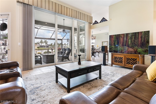 living room with a water view, ceiling fan, and light tile patterned floors