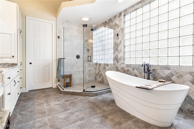 bathroom featuring vanity, separate shower and tub, and tile walls