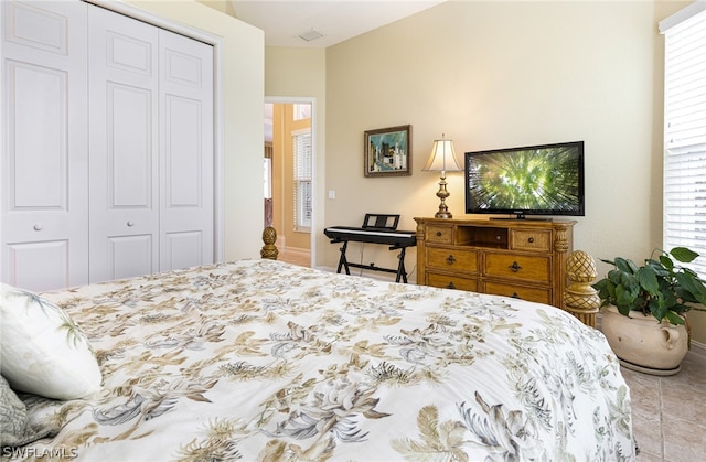 bedroom with light tile patterned floors and a closet