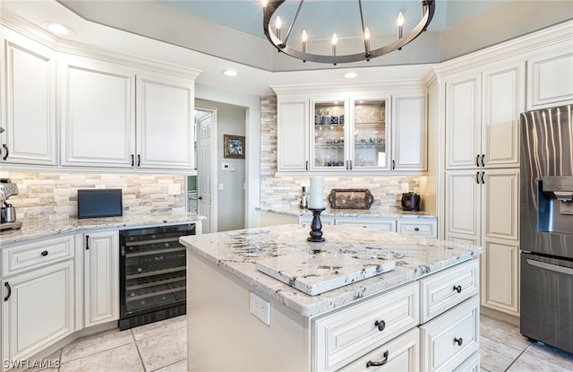 kitchen featuring wine cooler, hanging light fixtures, white cabinets, and stainless steel refrigerator with ice dispenser