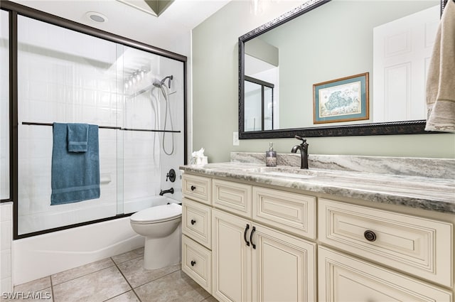 full bathroom with toilet, tile patterned floors, vanity, and shower / bath combination with glass door