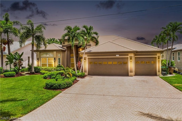 mediterranean / spanish house with a yard and a garage