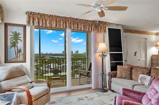 living room featuring ceiling fan and a textured ceiling