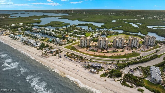 birds eye view of property with a water view and a beach view