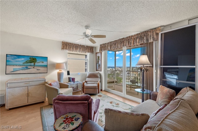 living room featuring wood finished floors, a textured ceiling, and ceiling fan