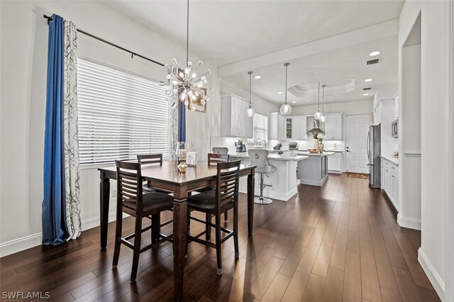 dining room with dark hardwood / wood-style flooring and a chandelier