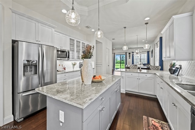 kitchen with backsplash, white cabinetry, and stainless steel appliances