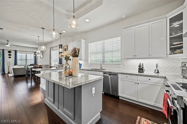 kitchen featuring white cabinets, pendant lighting, a kitchen island, and appliances with stainless steel finishes