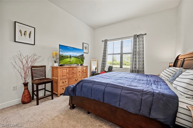 carpeted bedroom with lofted ceiling