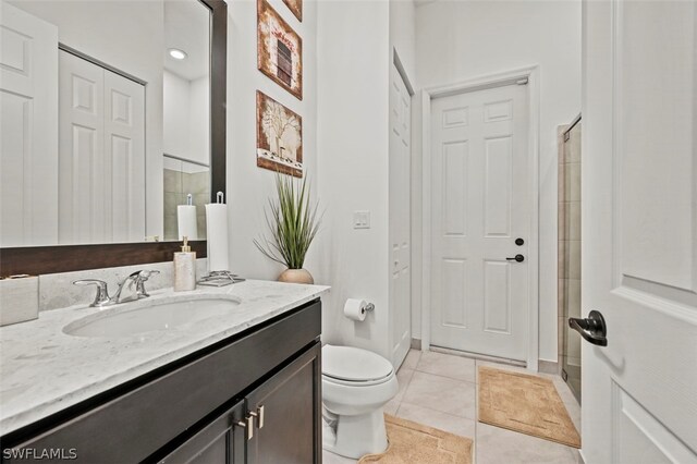 bathroom with toilet, vanity, and tile patterned floors