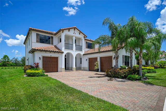 mediterranean / spanish home with a front yard and a balcony