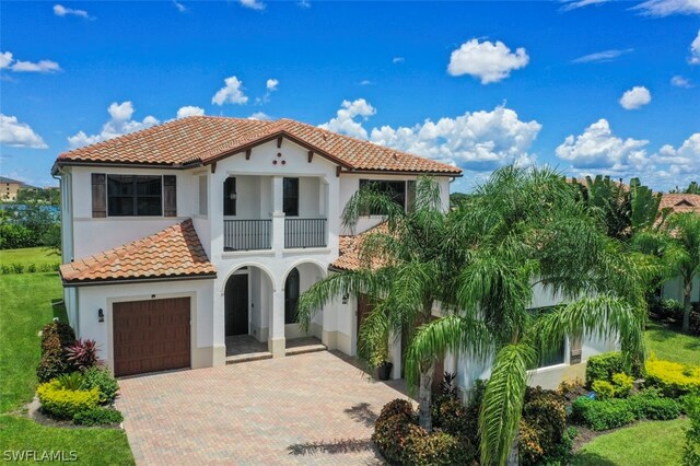 mediterranean / spanish home with a garage and a balcony