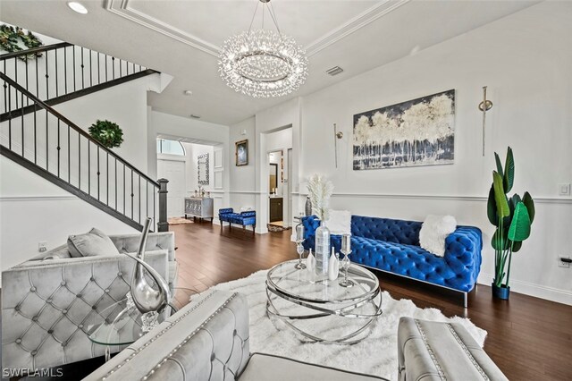 living room featuring crown molding, hardwood / wood-style floors, and an inviting chandelier