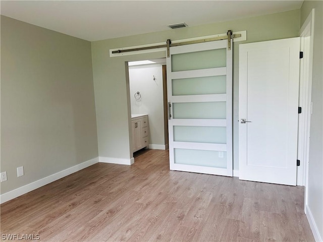 interior space featuring a barn door and light hardwood / wood-style floors