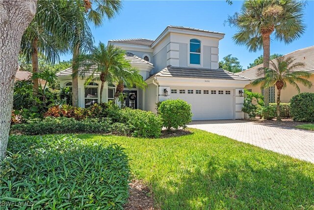 mediterranean / spanish house with a garage and a front lawn