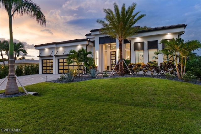 contemporary house featuring a garage and a lawn