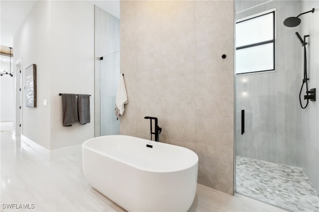 bathroom with tile walls and separate shower and tub