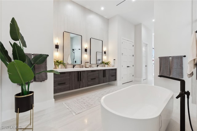 bathroom with a washtub, vanity, wood-type flooring, and a high ceiling