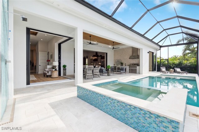 view of swimming pool featuring a patio area, grilling area, a lanai, ceiling fan, and exterior kitchen