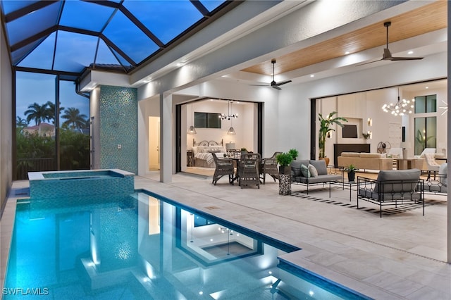 pool at dusk featuring a patio, an outdoor living space with a fireplace, an in ground hot tub, and ceiling fan