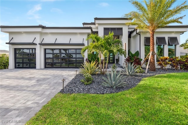 view of front of home with a garage and a front lawn