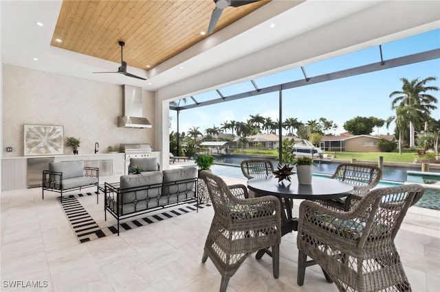 view of patio / terrace with outdoor lounge area, exterior kitchen, grilling area, ceiling fan, and a water view