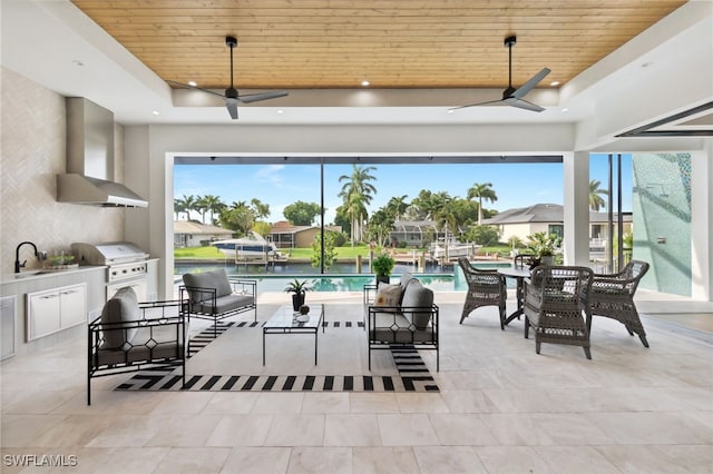 view of patio / terrace with a water view, area for grilling, ceiling fan, and sink