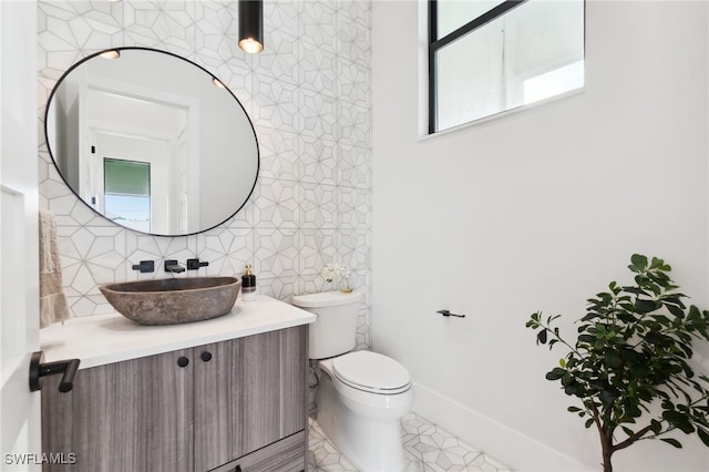 bathroom with tasteful backsplash, vanity, tile patterned floors, and toilet