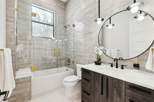 full bathroom with bath / shower combo with glass door, tile walls, backsplash, vanity, and toilet