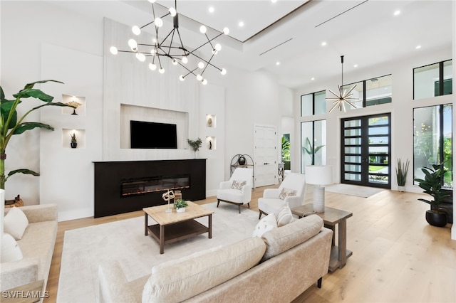 living room featuring a towering ceiling and light hardwood / wood-style flooring