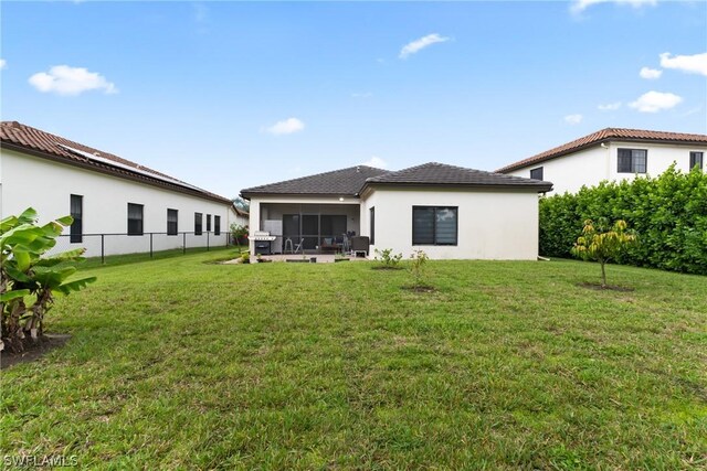 back of house featuring a yard and a sunroom