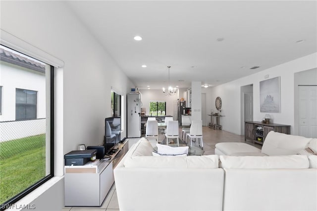 living room featuring an inviting chandelier, plenty of natural light, and light tile patterned floors