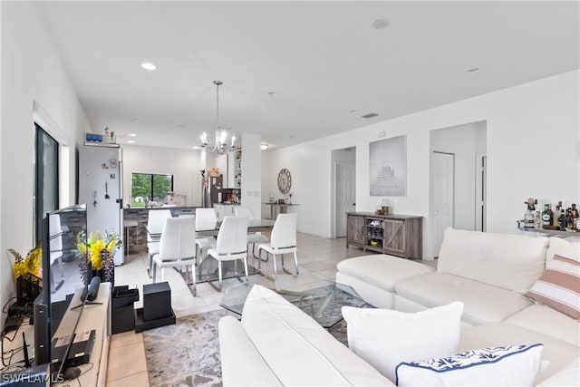 living room with light tile patterned floors and a notable chandelier