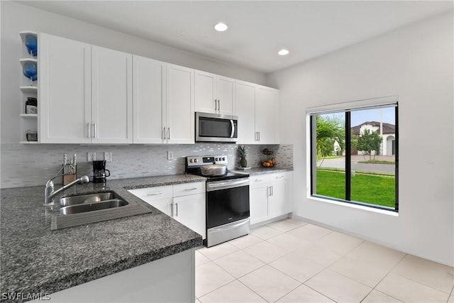 kitchen featuring sink, decorative backsplash, white cabinets, and appliances with stainless steel finishes