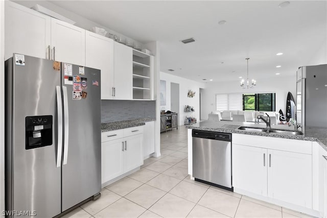 kitchen with sink, appliances with stainless steel finishes, dark stone counters, decorative backsplash, and white cabinets