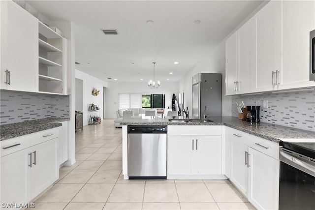 kitchen featuring sink, white cabinetry, dark stone counters, kitchen peninsula, and stainless steel appliances