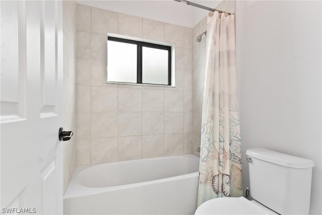 bathroom featuring toilet and shower / bath combo with shower curtain