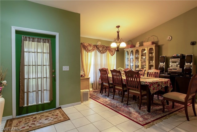 tiled dining area featuring a notable chandelier, a healthy amount of sunlight, and lofted ceiling