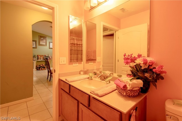 bathroom featuring tile patterned flooring, toilet, and vanity