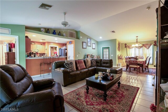 living room with a notable chandelier, lofted ceiling, and light tile patterned floors